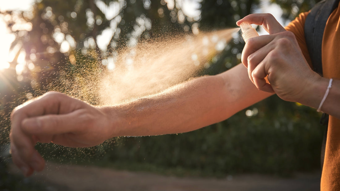 Person spraying insect repellant or after sun spray onto arm.