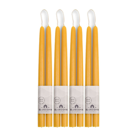 Set of eight yellow candles with white wicks on a white background, branded 'Bluecorn'.