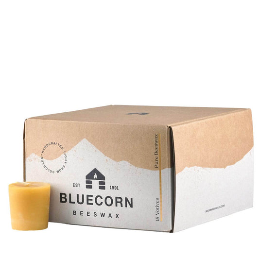 Box of Bluecorn Beeswax candles with a single votive candle on a white background