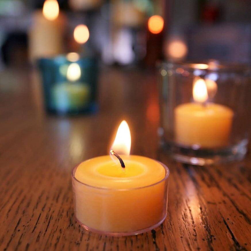 Bluecorn Tea Light Candle on a wooden surface with blurred background