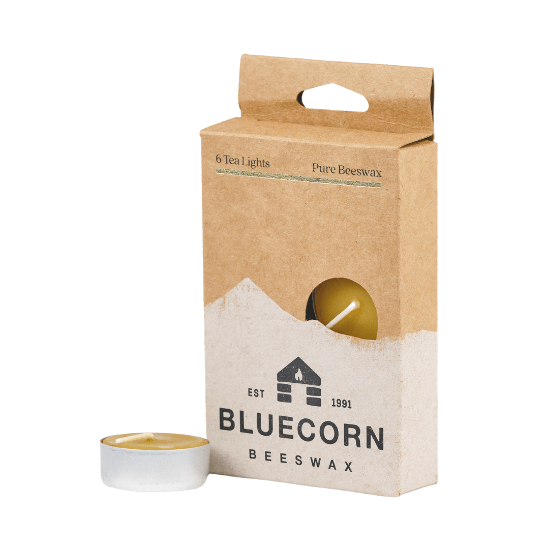 Box of Bluecorn Beeswax tea lights with a visible candle on a white background