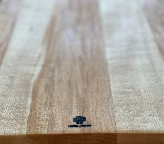 Wooden cutting board with a visible brand logo on a light background