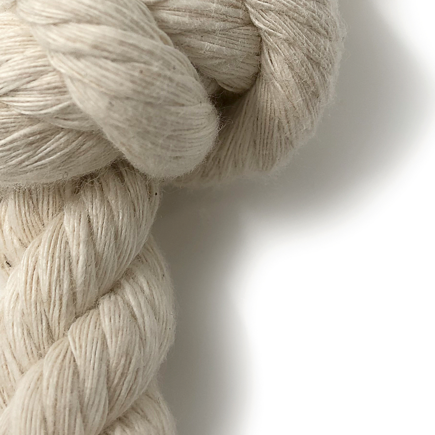 Close-up of organic cotton dog rope toy on a white background