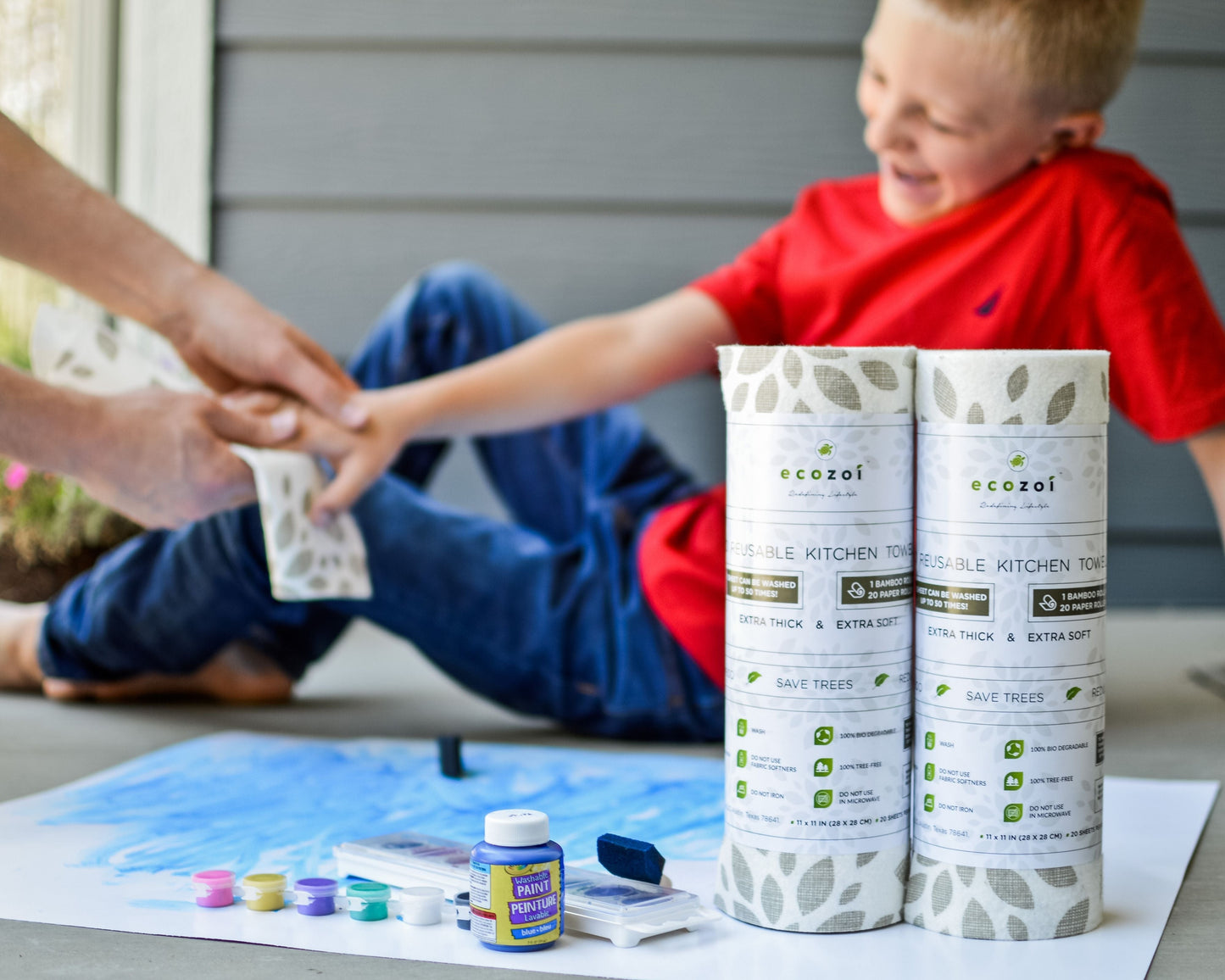 Child sitting on a porch with eco-friendly ecozoi bamboo kitchen towels and art supplies.