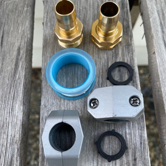 Collection of garden hose repair kit parts including brass connectors, a blue washer, and metal components on a wooden surface.