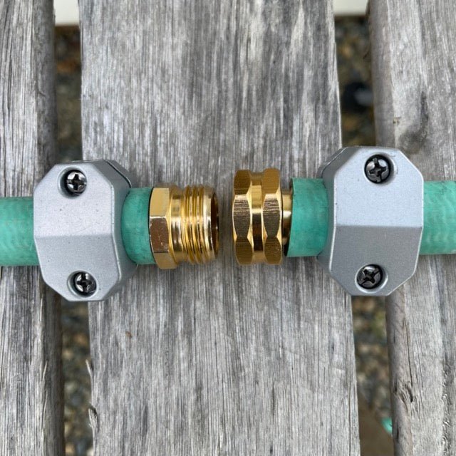 Two garden hose connectors with brass fitting on a wooden background