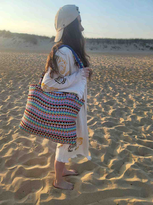 Person holding a colorful Handwoven Turkish Cotton Tote – Artisan-Made & Travel Ready - on a sandy beach