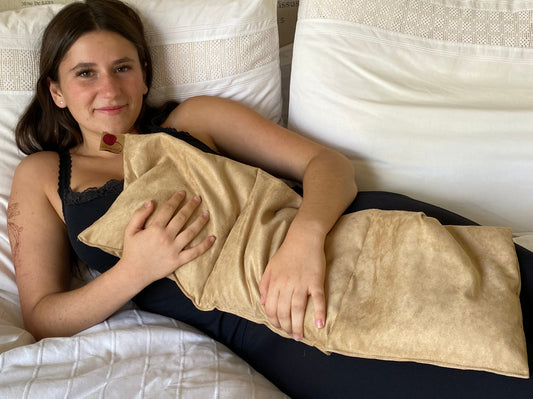 Person lying on a bed with a Hot Cherry Triple Square Pillow Maraschino Ultra Suede Hot Pad across their stomach and chest