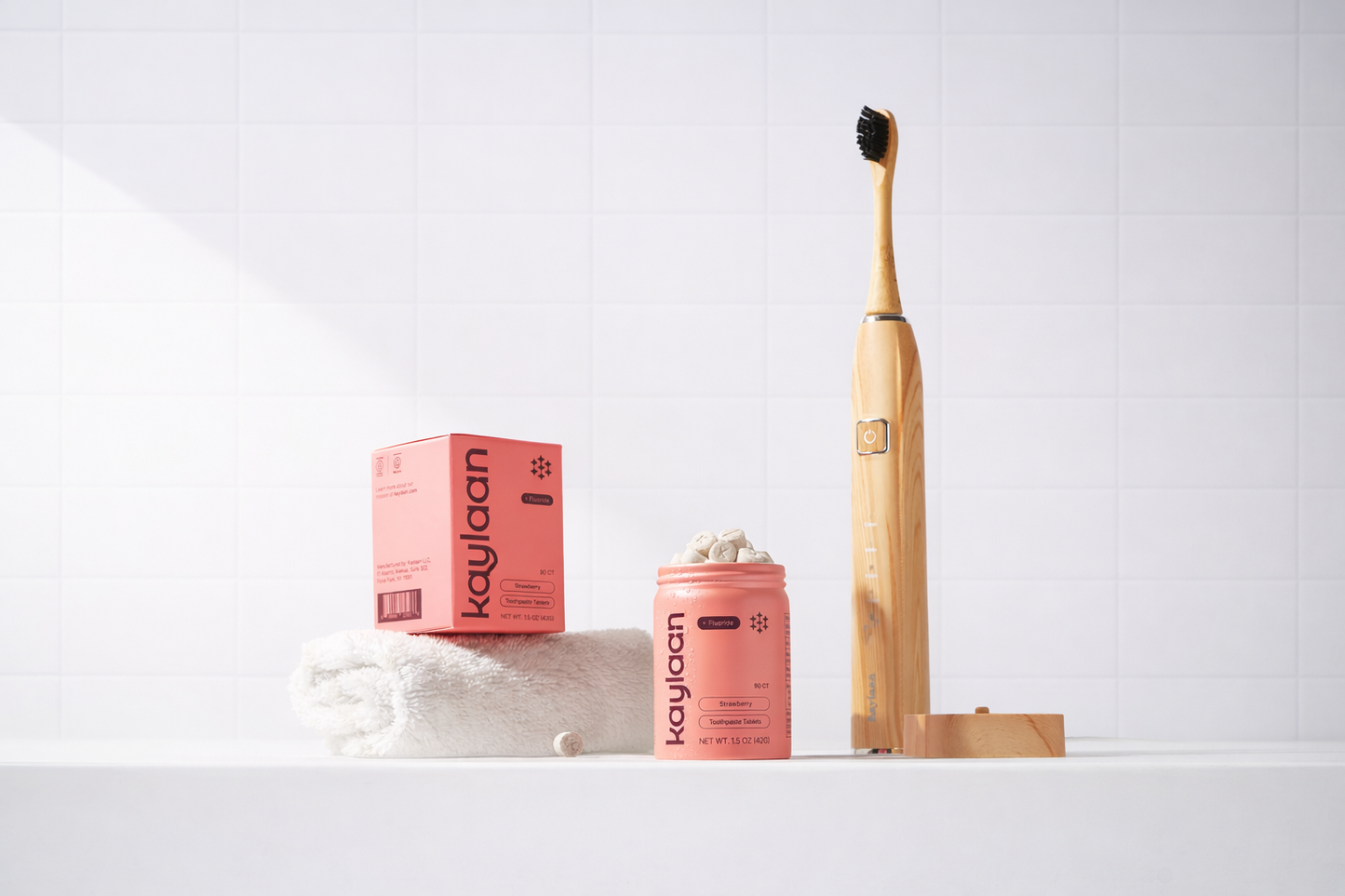 Sustainable Bamboo Electric Toothbrush by Kaylaan with brushing tablets on a white surface with a white background
