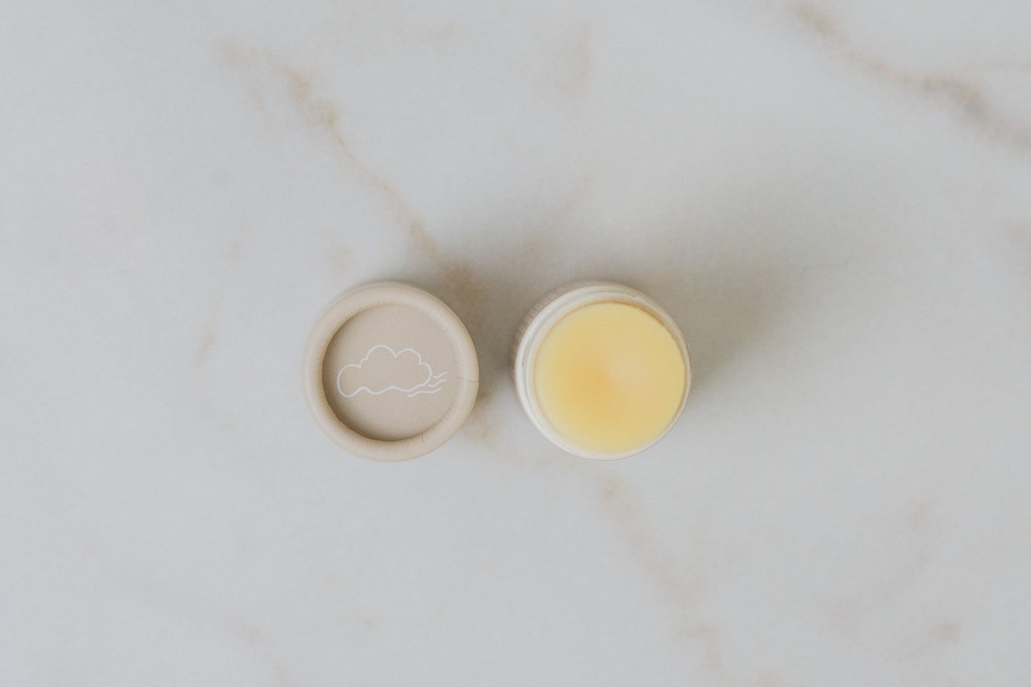 Open tupe of No Tox Life SolidSilk Lip Butter - Vanilla Cloud - on a marble surface