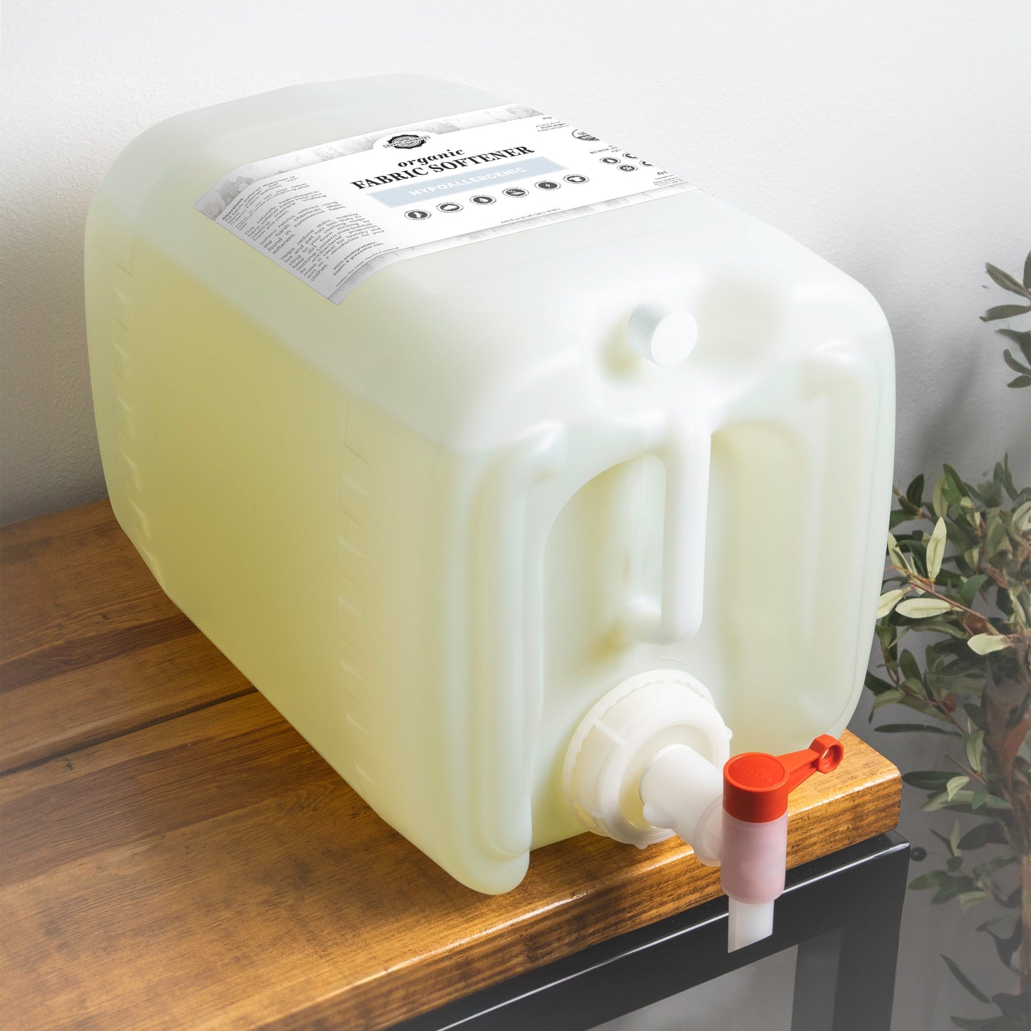 5 gallon plastic container of organic fabric softener with a pump on a wooden surface