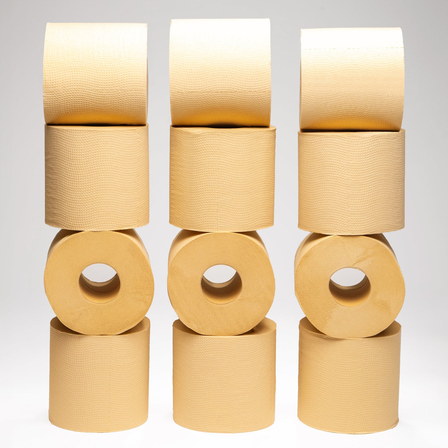Stacks of beige Panda Eco Paper Bamboo Toilet Paper rolls on a light gray background