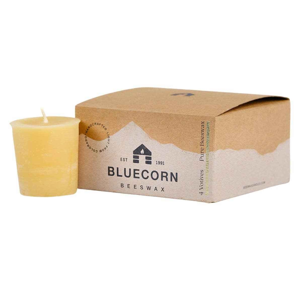 Beeswax candle next to a Bluecorn Beeswax packaging box on a white background