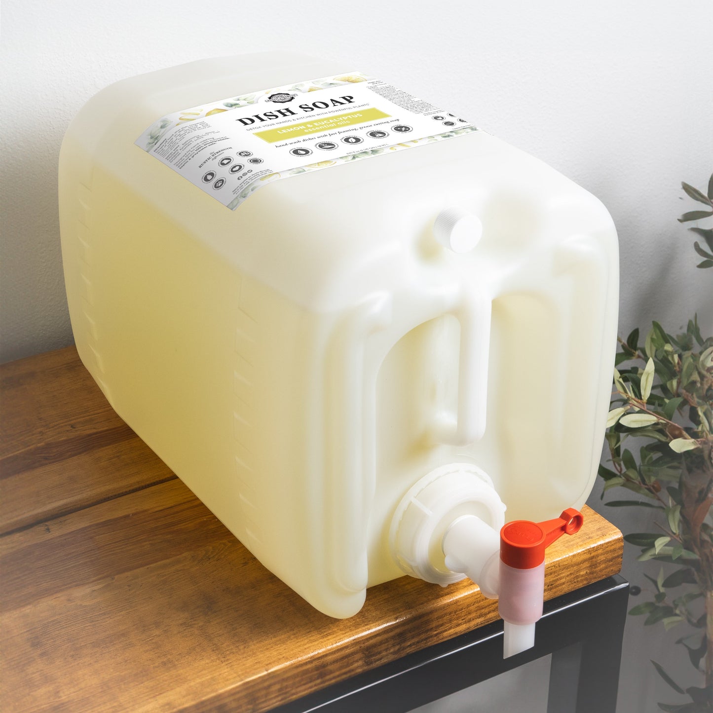 5 gallon container of Rustic Strength Lemon & Eucalyptus Dish Soap with a pump on a wooden surface.