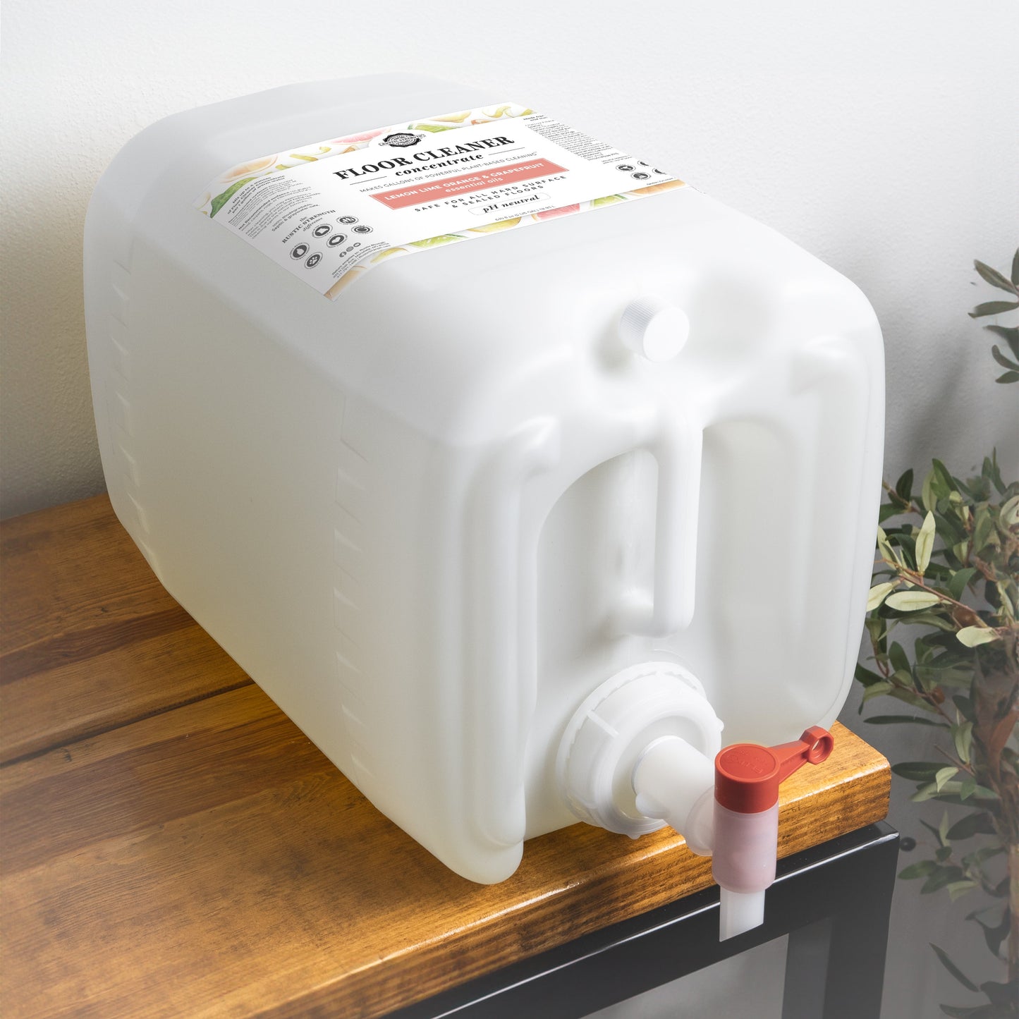 5-gallon container Rustic Strength Floor Cleaner Concentrate with a red valve on a wooden surface