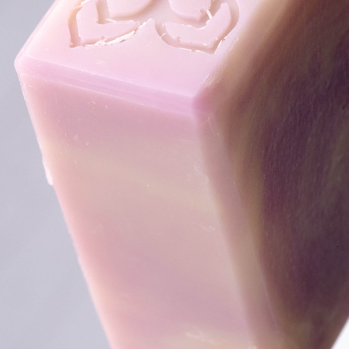 Close-up of a lavender soap bar with a decorative cutout on a gray background