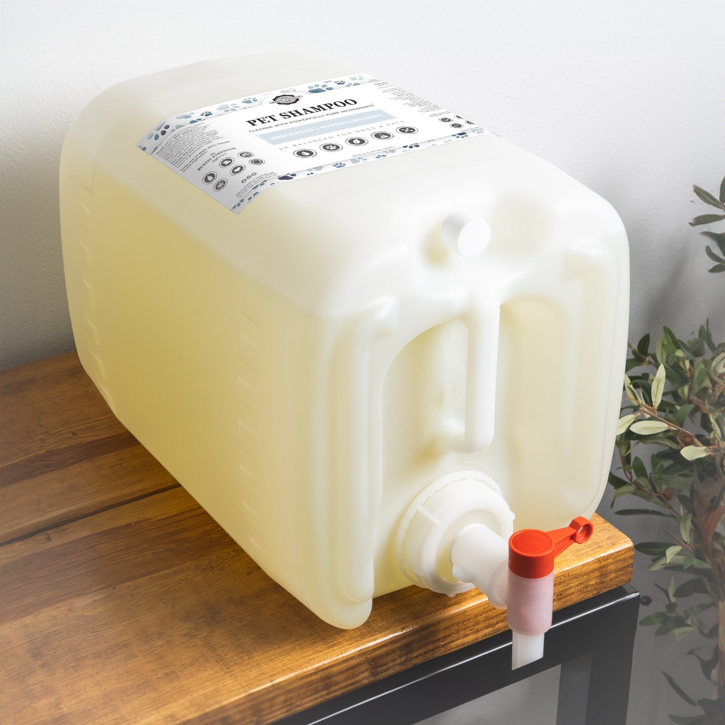 5 gallon container of pet shampoo with a red nozzle on a wooden surface.