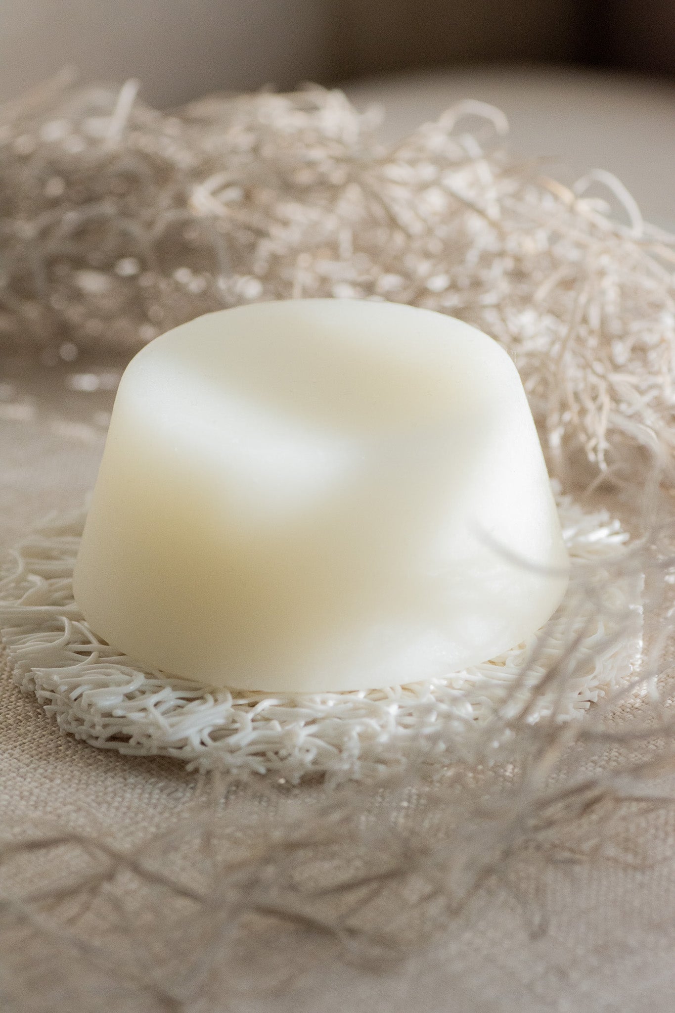White shampoo bar on a textured beige surface