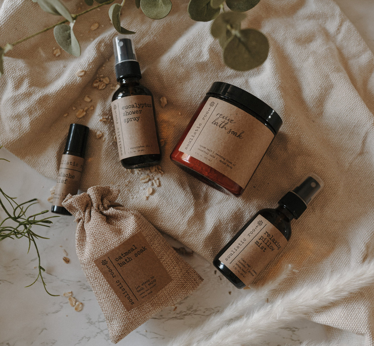 Spa Day Gift Set by Soulistic Root, products displayed with eucalyptus leaves on beige linen