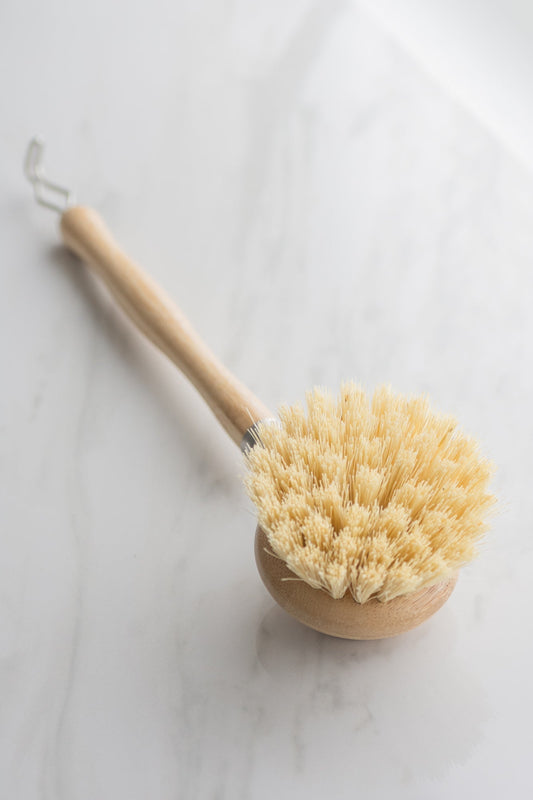 Vegan bristle brush for dish washing with a bamboo handle on a light background
