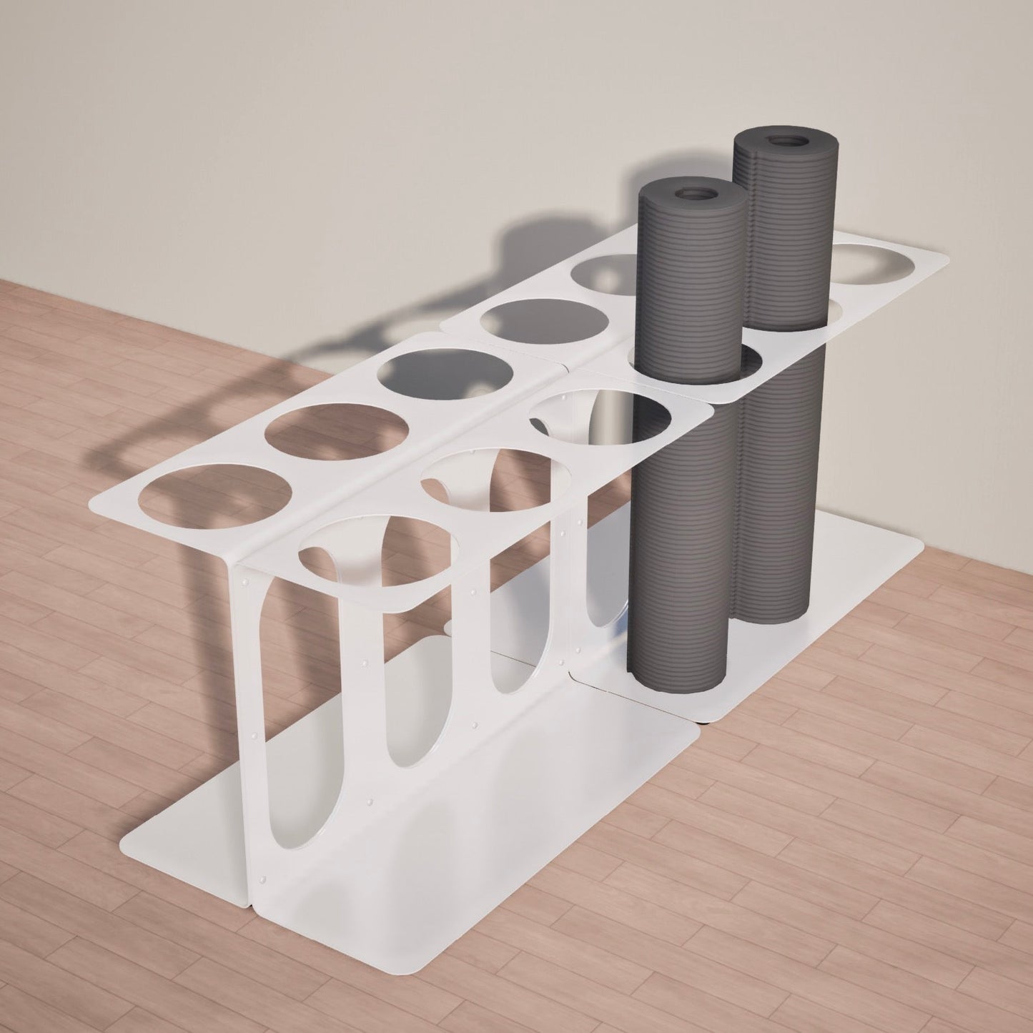 White Yoke yoga mat rack with two rolled-up yoga mats of twelve on a wooden floor.