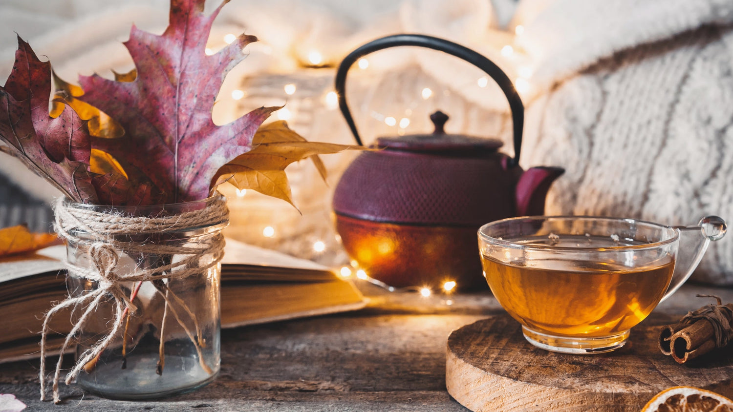 Friends laughing at an outdoor fire with a warm beverage