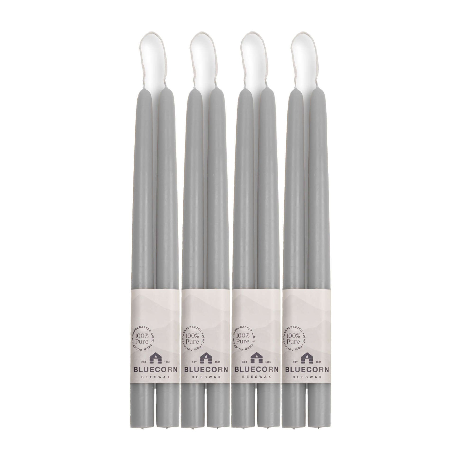 Set of eight gray candles with visible labels on a white background