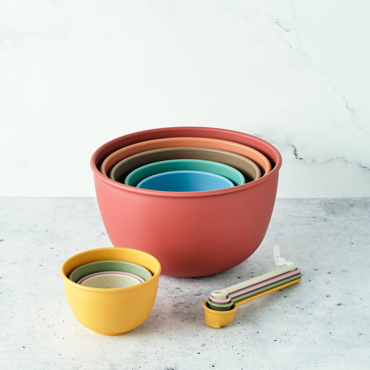 Set of eco-friendly Astrik mixing bowls, measuring cups and spoons in desert bloom on a light surface with a white background