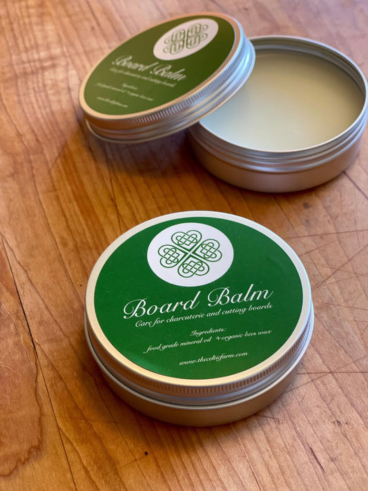 Two tins of Board Balm on a wooden surface