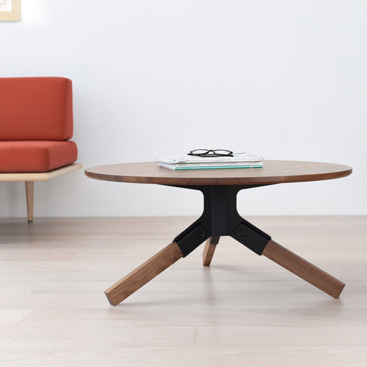 Conrad Coffee Table in Solid Walnut with black metal base in a minimalistic room.