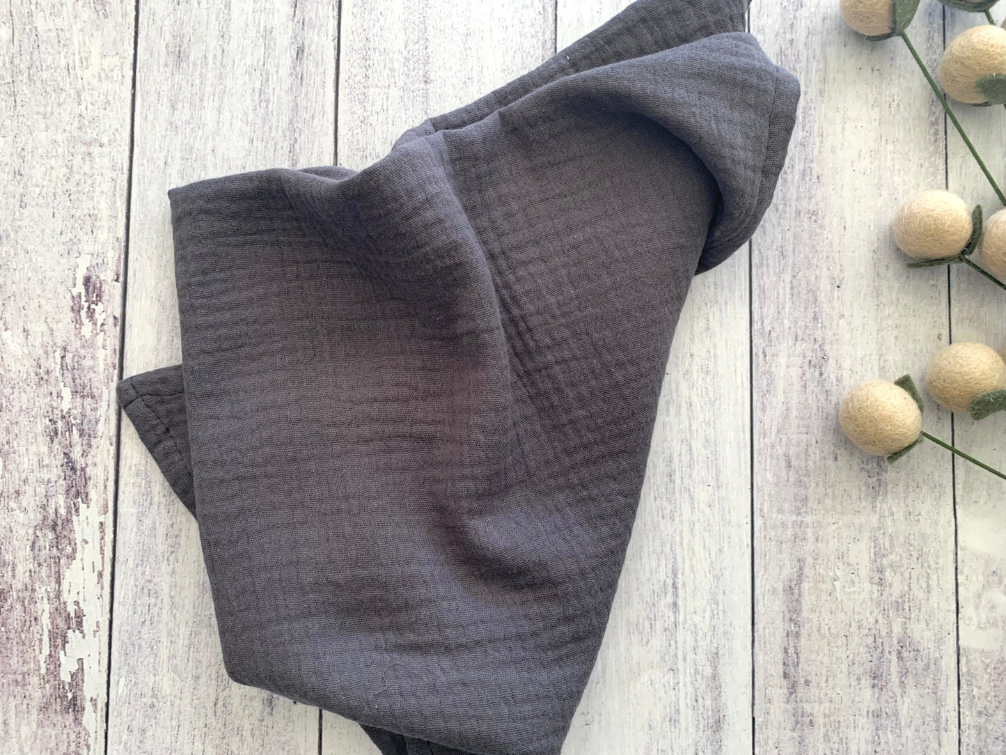 Charcoal Grey 100% cotton dinner napkin from Dot and Army, arranged on a wooden surface