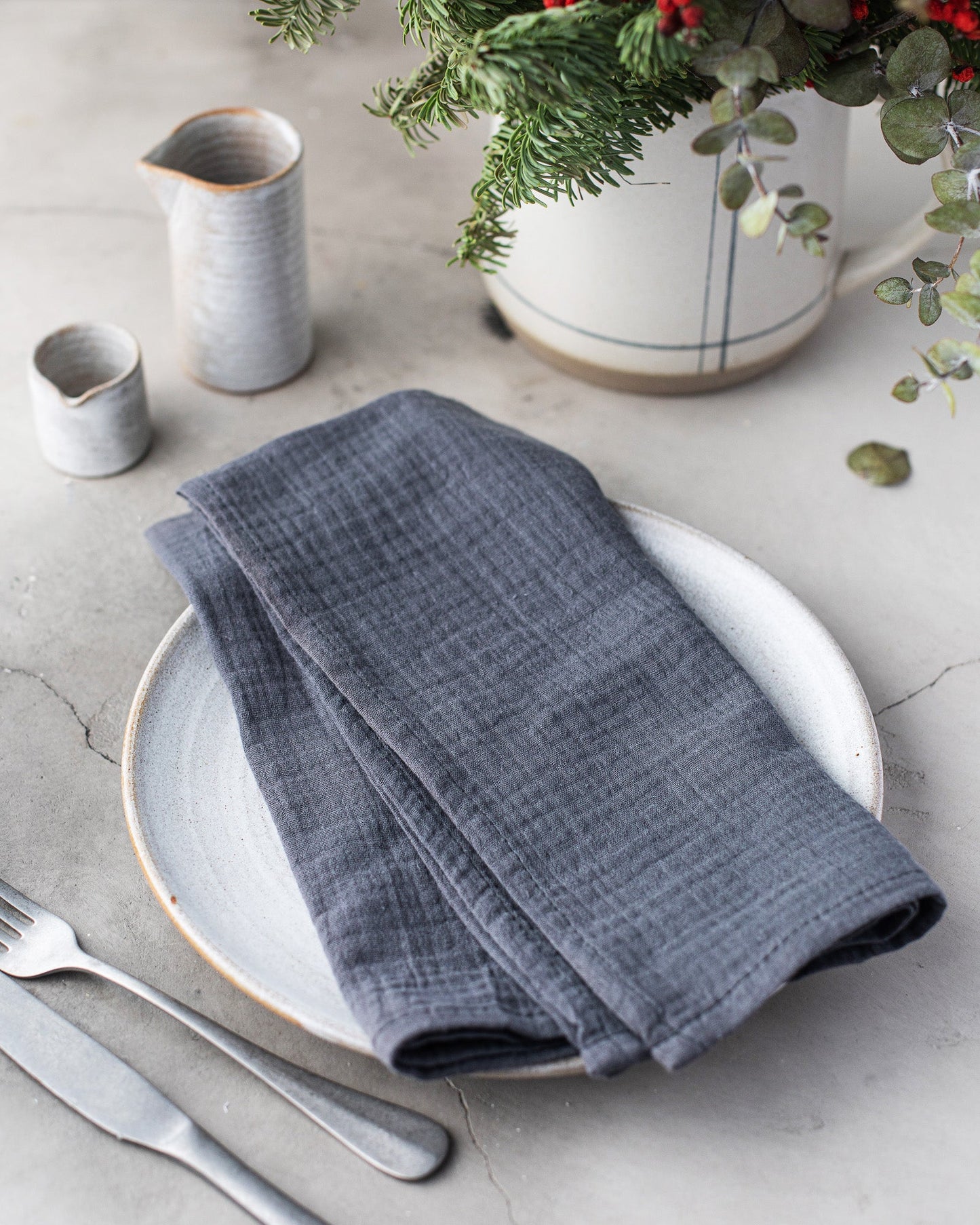 Gray 100% cotton dinner napkin from Dot and Army, arranged on a wooden surface