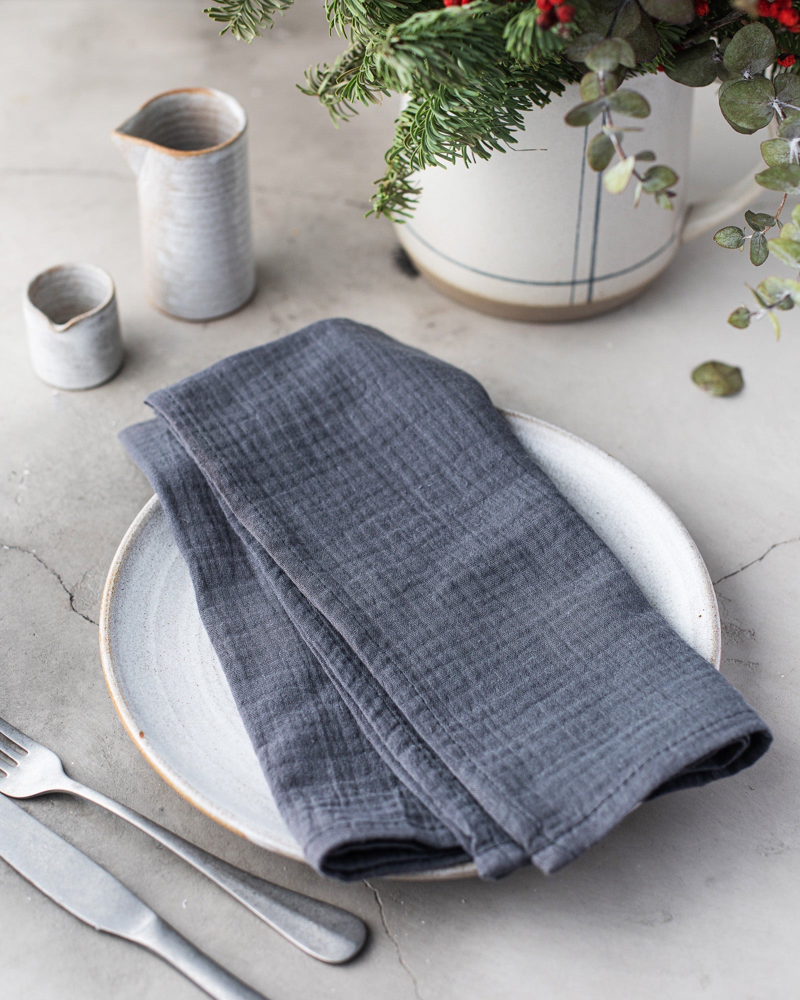 Gray 100% cotton dinner napkin from Dot and Army, arranged on a wooden surface