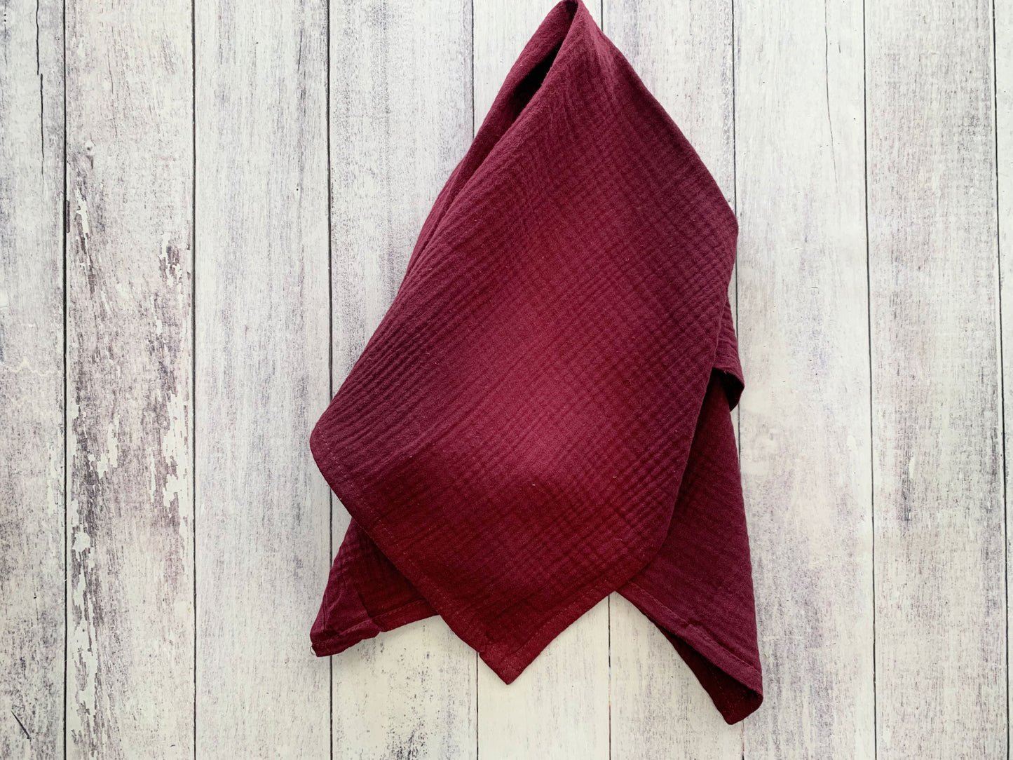 Merlot 100% cotton dinner napkin from Dot and Army, arranged on a wooden surface