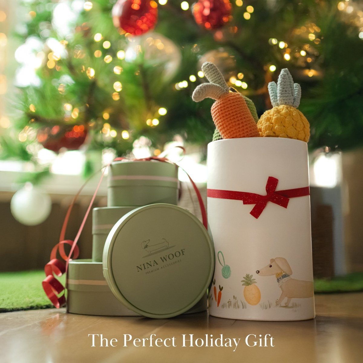Decorative Organic Cotton Veggie Dog Toy Bundle – Eco-Friendly Squeaky Carrot, Pear & Pineapple Gift Set with 'Nina Woof' branding in front of a Christmas tree.