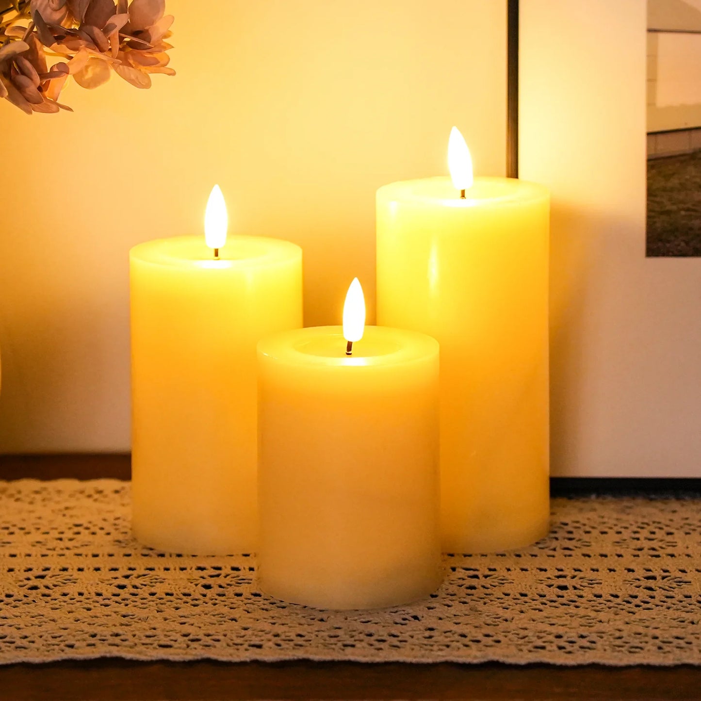 Three lit flameless LED candles on a textured surface with a warm glow