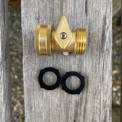 Brass garden shuff-off valve with two black washers on a wooden background