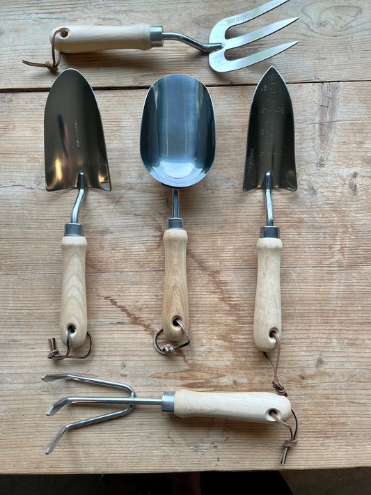 5-piece set of essential gardening tools with wooden handles and stainless steel, displayed on a wooden surface
