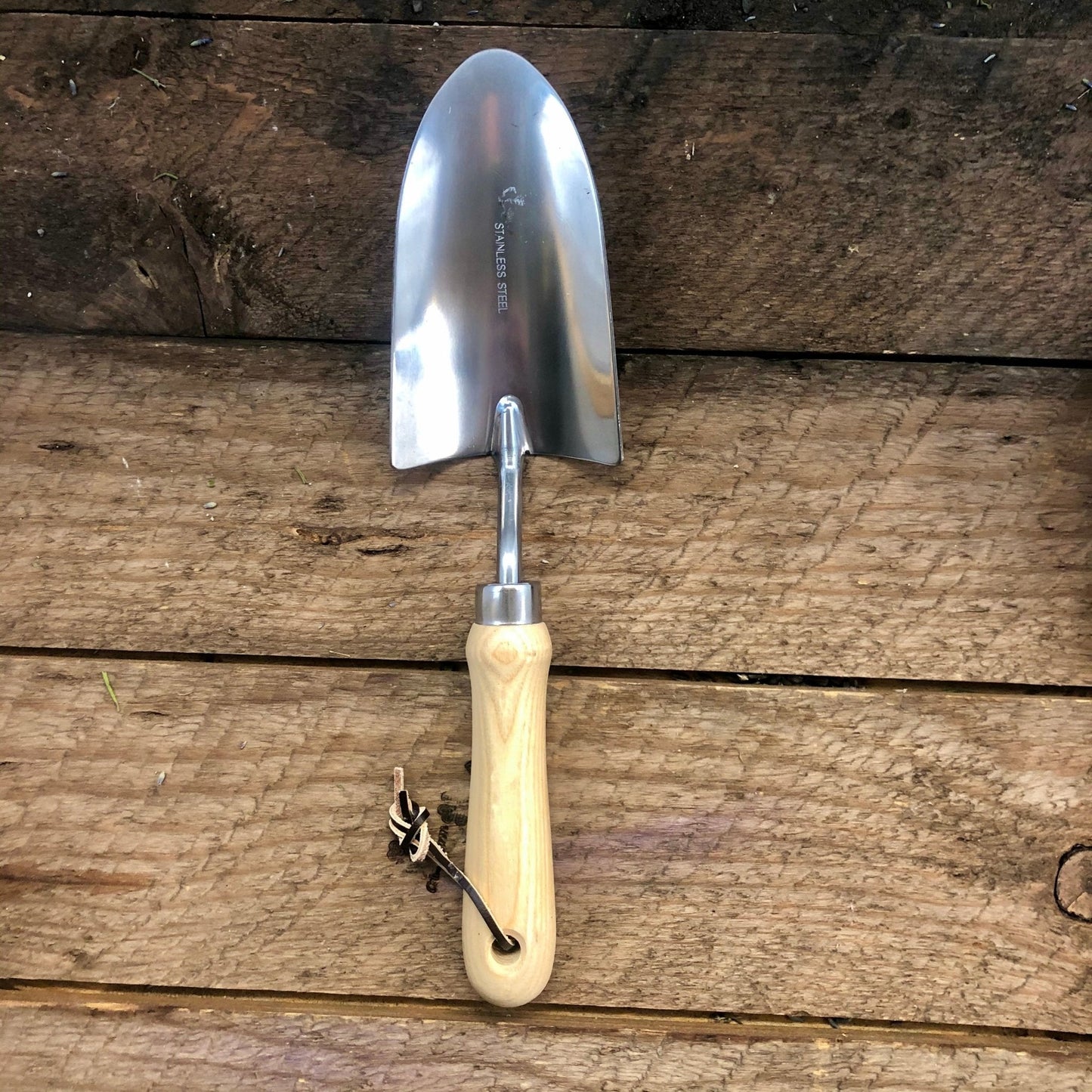 Gardening trowel with wooden handle on a wooden surface