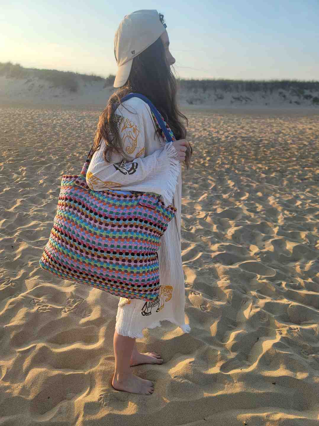 Person holding a colorful Handwoven Turkish Cotton Tote – Artisan-Made & Travel Ready - on a sandy beach