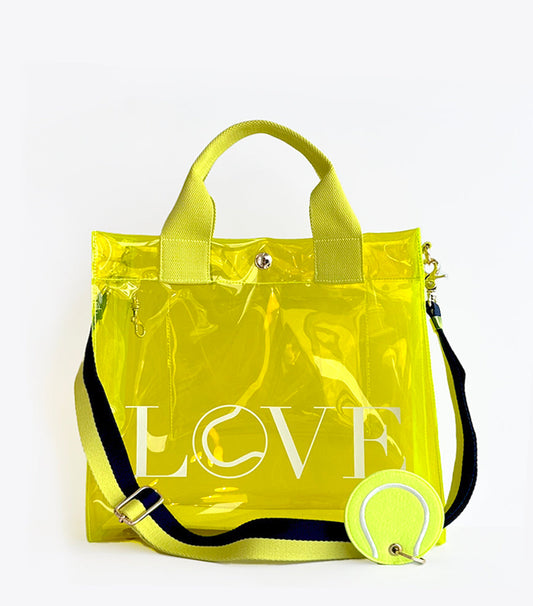 Clear LOVE tote bag, stadium-approved transparent carryall for events. Yellow transparent tote bag with 'LOVE' text and a tennis ball on a white background