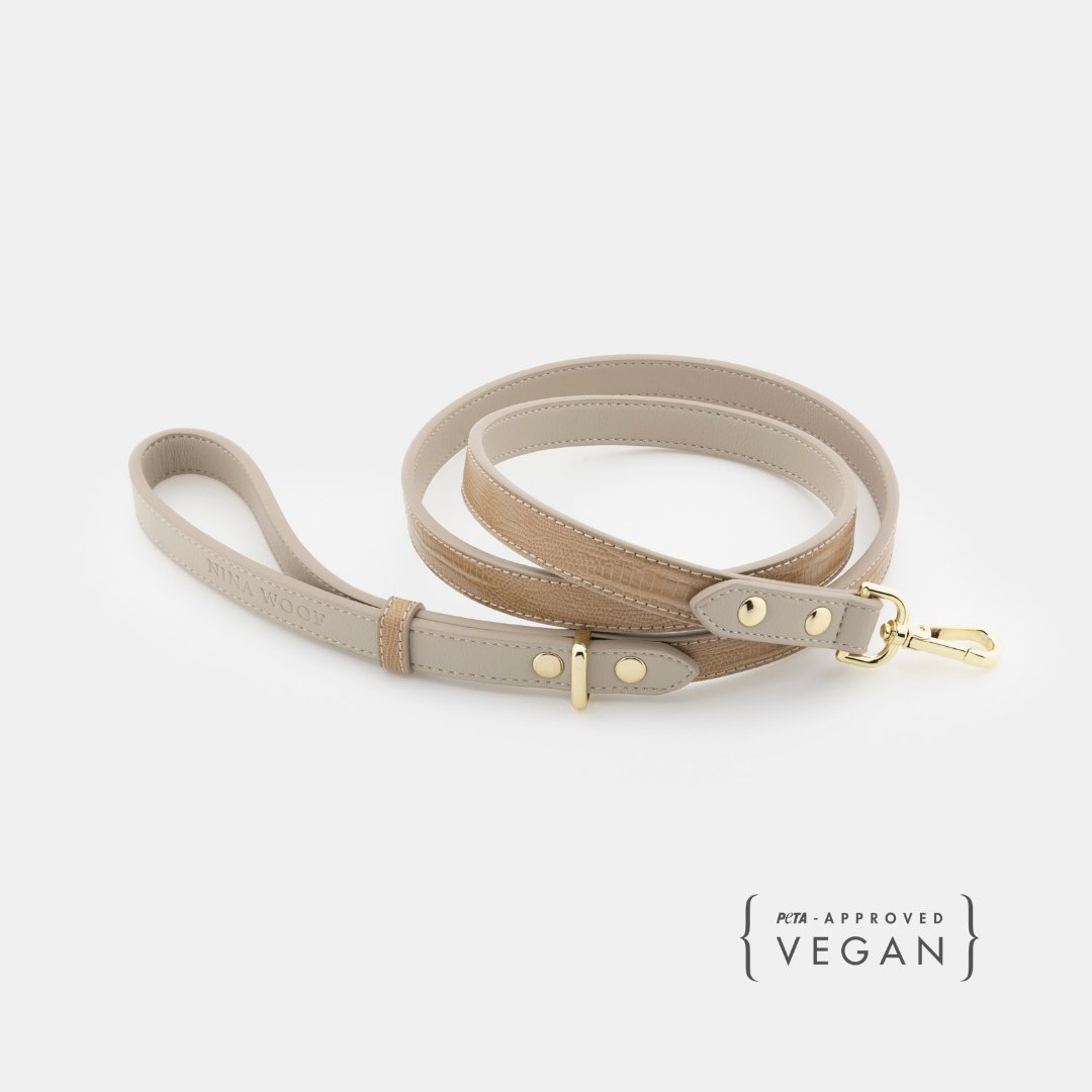 Beige Nina Woof Vegan Leather Dog Leash with gold hardware on a white background, featuring 'PETA-approved Vegan' label.