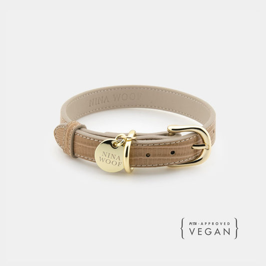 Beige Nina Woof vegan leather dog collar with gold hardware on a white background, featuring the brand 'Nina Woof'.