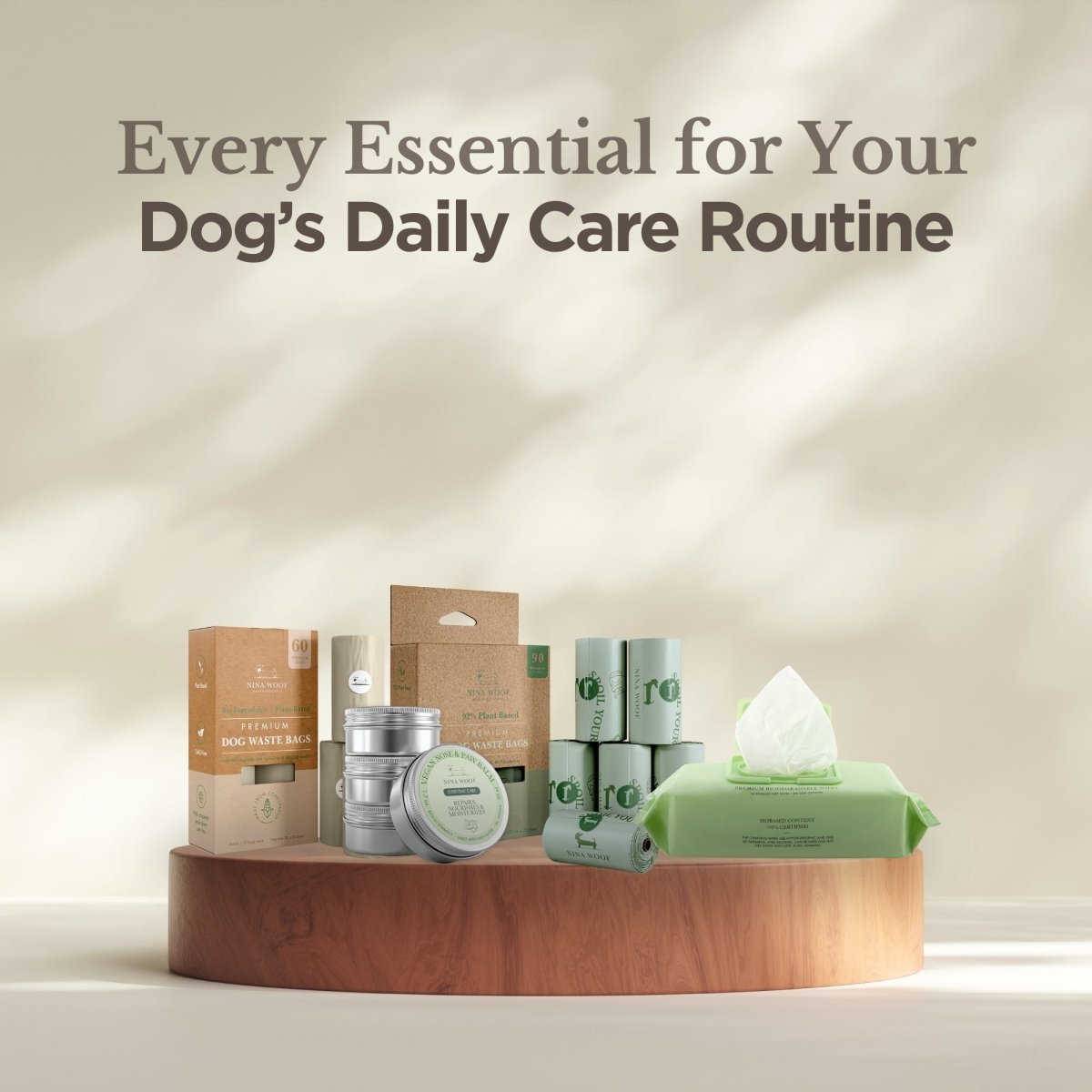 NIna Woof dog care products, including premium biodegradable dog waste bags and rolls in cardboard packaging, biodegradable pet wipes in green containers, and paw and nose balm on a wooden stand with a neutral background.