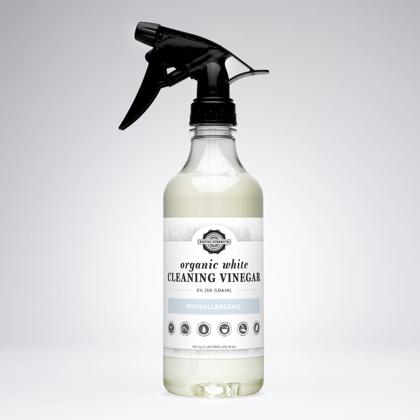 Bottle of organic white cleaning vinegar with a black spray nozzle on a light gray background