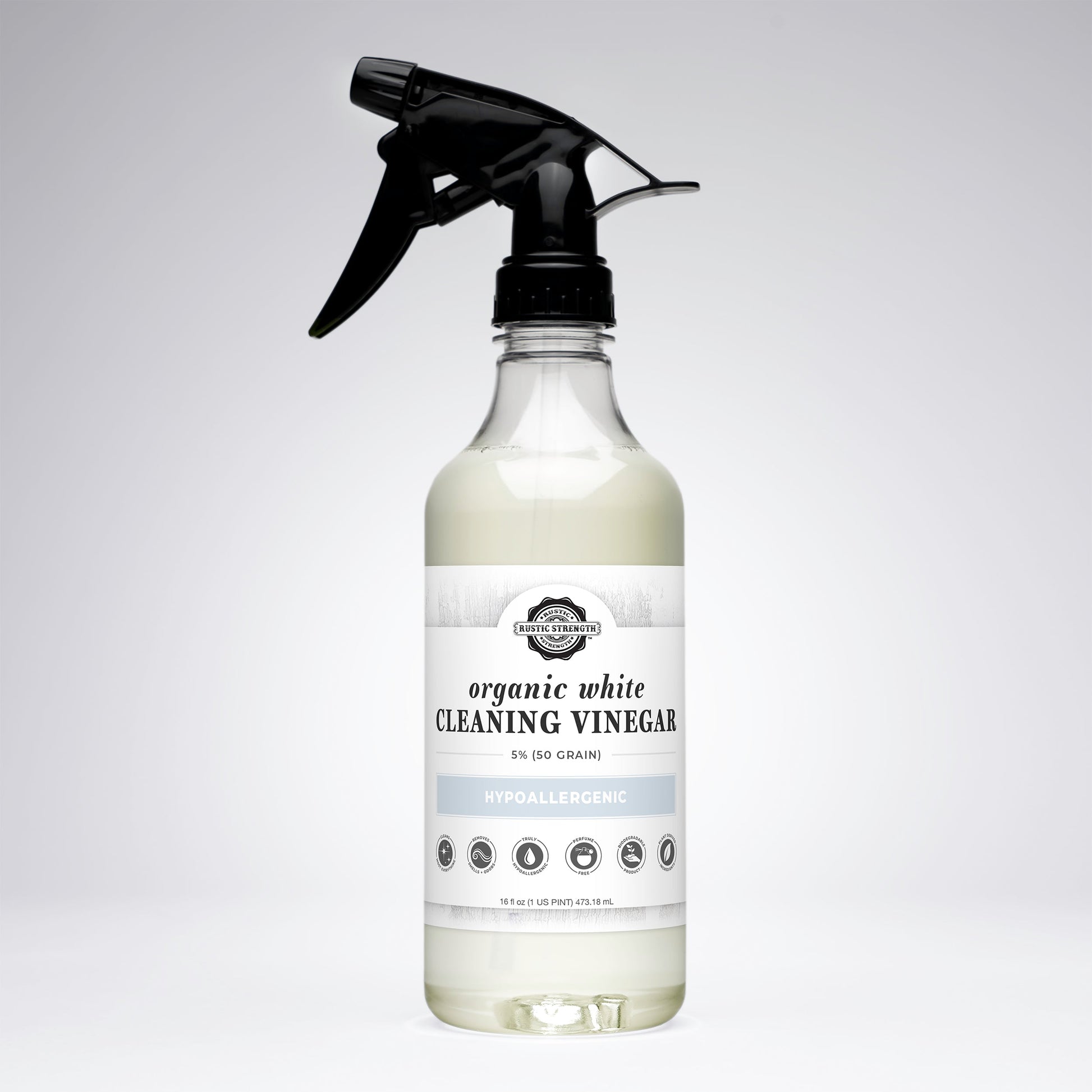 Bottle of organic white cleaning vinegar with a black spray nozzle on a light gray background
