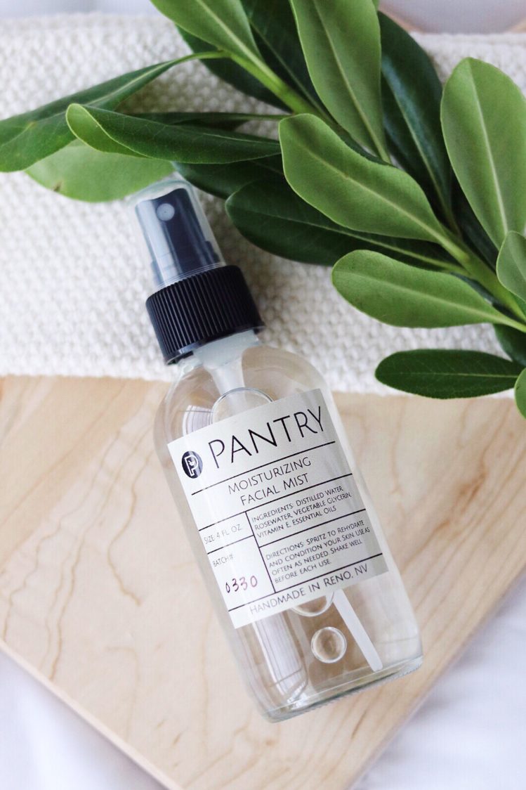 Pantry Moisturizing Facial Mist Spray made with rosewater and essential oils, shown on a wooden board with a plant sprig