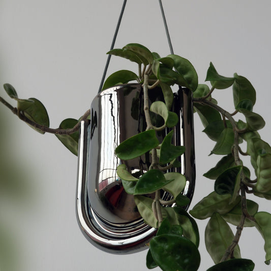 Portico Hanging Planter in Chrome Stoneware with green leaves against a neutral background