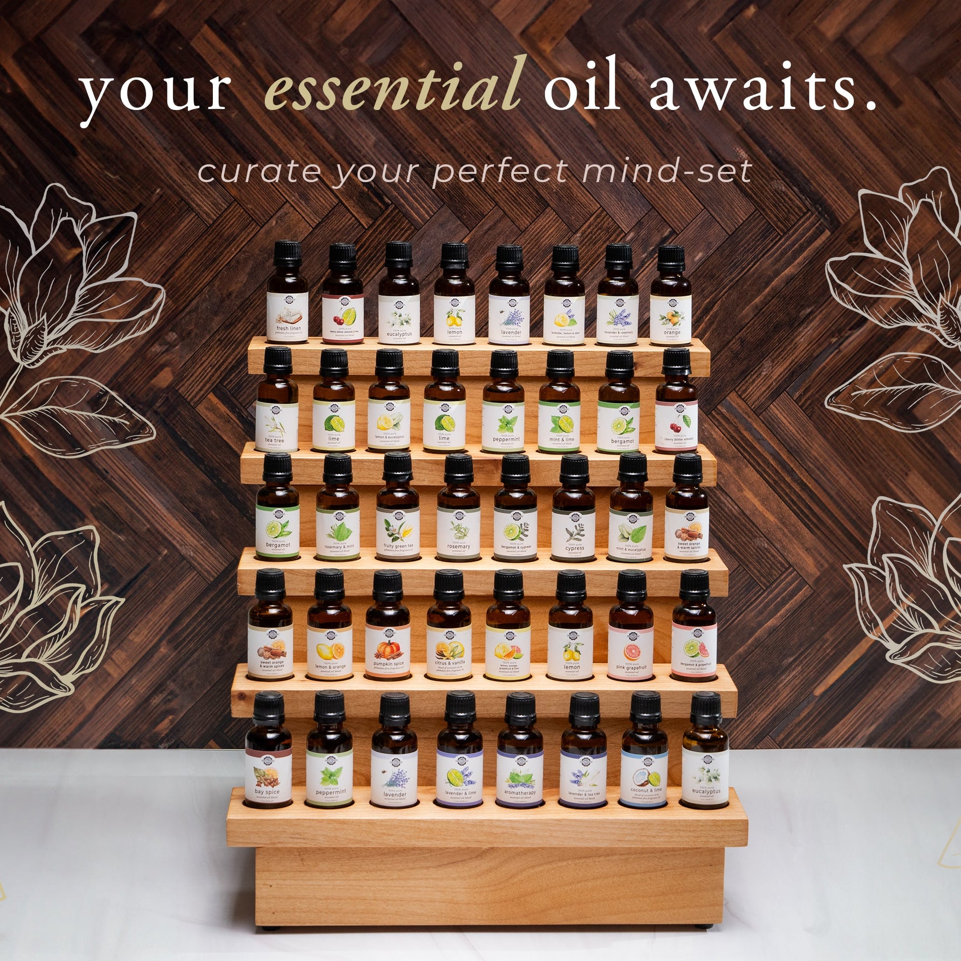 Display of essential oil bottles on a wooden stand with decorative floral elements and text on a wooden background.
