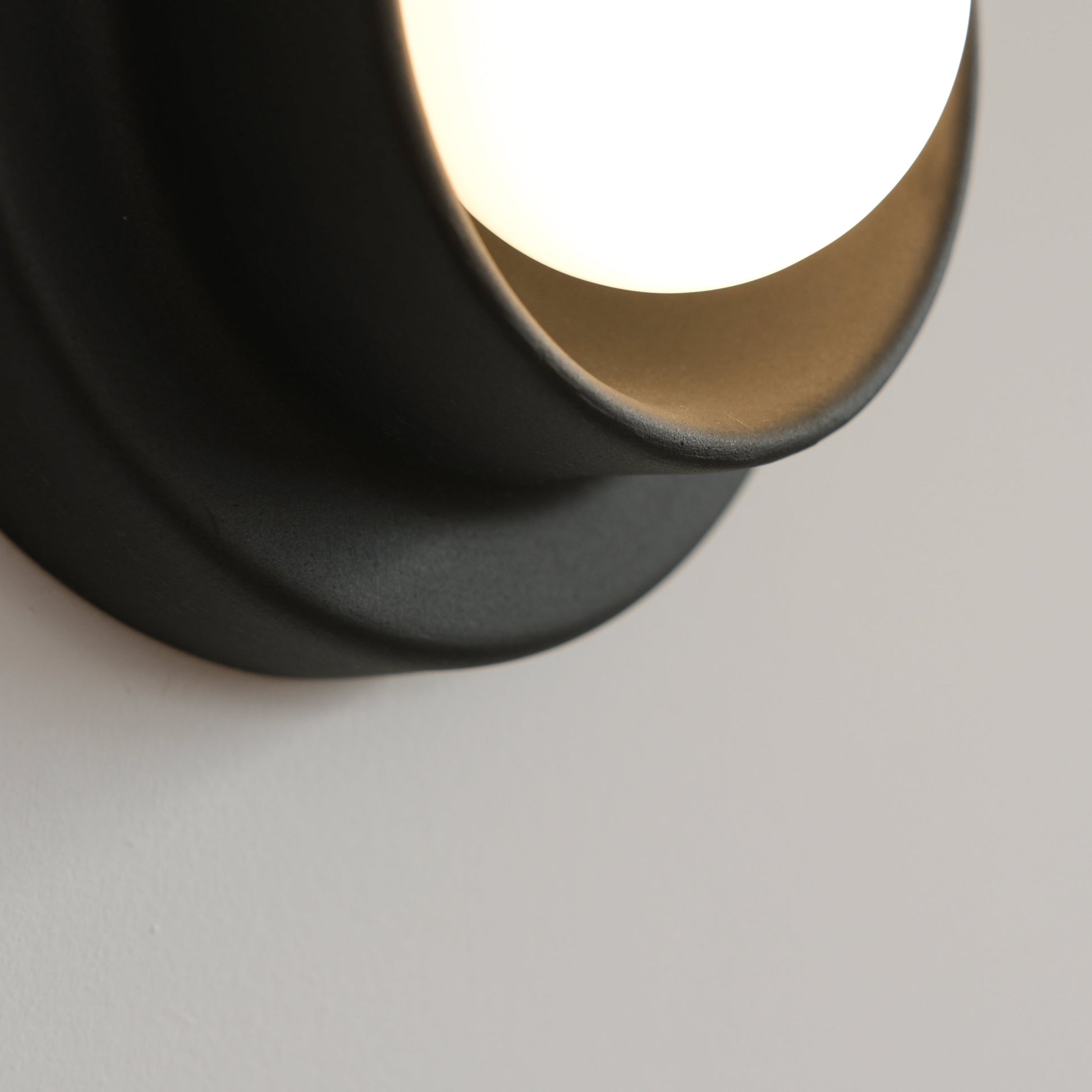 Black Misewell Q Sconce Handcrafted Ceramic Wall Light on a white wall